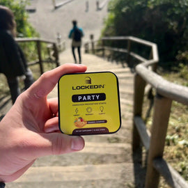 locked in party hangover supplement holding in hand at beach