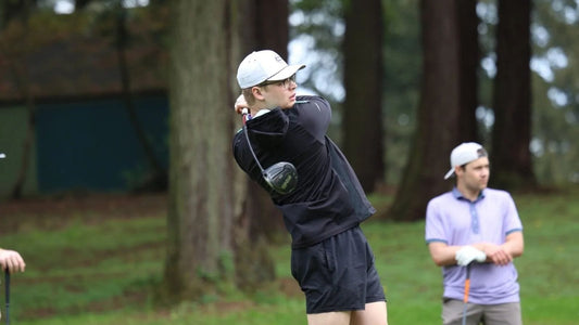 Hunter in black clothing hitting a driver in a competitive golf tournament