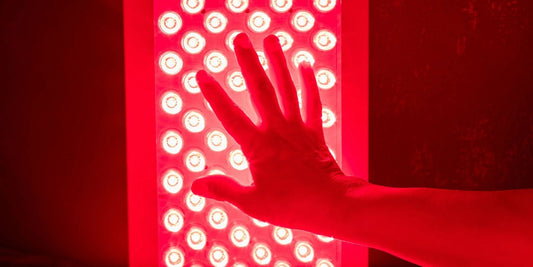 hand hovering over a red light panel for skin health and anti-aging effects